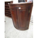 George III oak hanging bow fronted corner cabinet with two panel doors