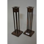 Pair of early 20th Century Arts and Crafts oxidised copper candlesticks of square stylised form,