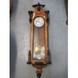 19th Century walnut and ebonised Vienna wall clock, the shaped surmount above a glazed door, the