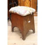Arts and Crafts Liberty type oak stool, the padded seat above tapering sides with arched friezes and