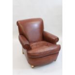 20th Century brown leather upholstered low seat armchair having loose cushion and turned oak front