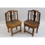 Pair of 20th Century Chinese hardwood side chairs having carved and spindle backs with cane seats,