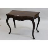 Antique mahogany serpentine shaped card table, the moulded fold-over top having baize lined interior