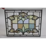 Small leaded and stained glass panel of stylised floral design, 15.5ins x 19ins