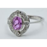 Platinum ring set oval pink sapphire surrounded by brilliant cut diamonds