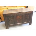 18th Century oak coffer, the hinged plank top above a carved three panel front, raised on stile feet