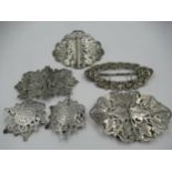 Collection of four various silver nurse's belt buckles together with another similar