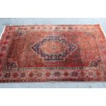 North East Persian rug with a single stepped medallion and all-over Herati design on a red ground