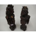 Pair of oriental carved hardwood figures of sages, (at fault), 15ins high and 14.5ins high