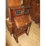 Arts & Crafts Oak bureau having two leaded glazed doors above a fall front and single drawer with