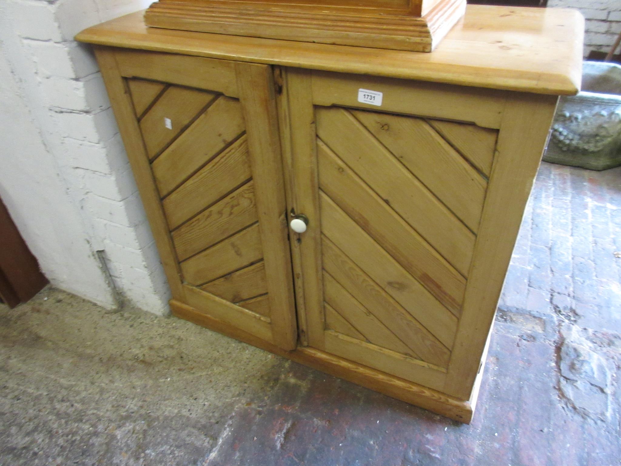 Victorian stripped pine two door cupboard of gothic design, on a plinth base, 31.5ins high x 35ins