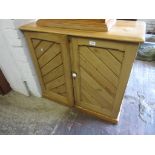 Victorian stripped pine two door cupboard of gothic design, on a plinth base, 31.5ins high x 35ins