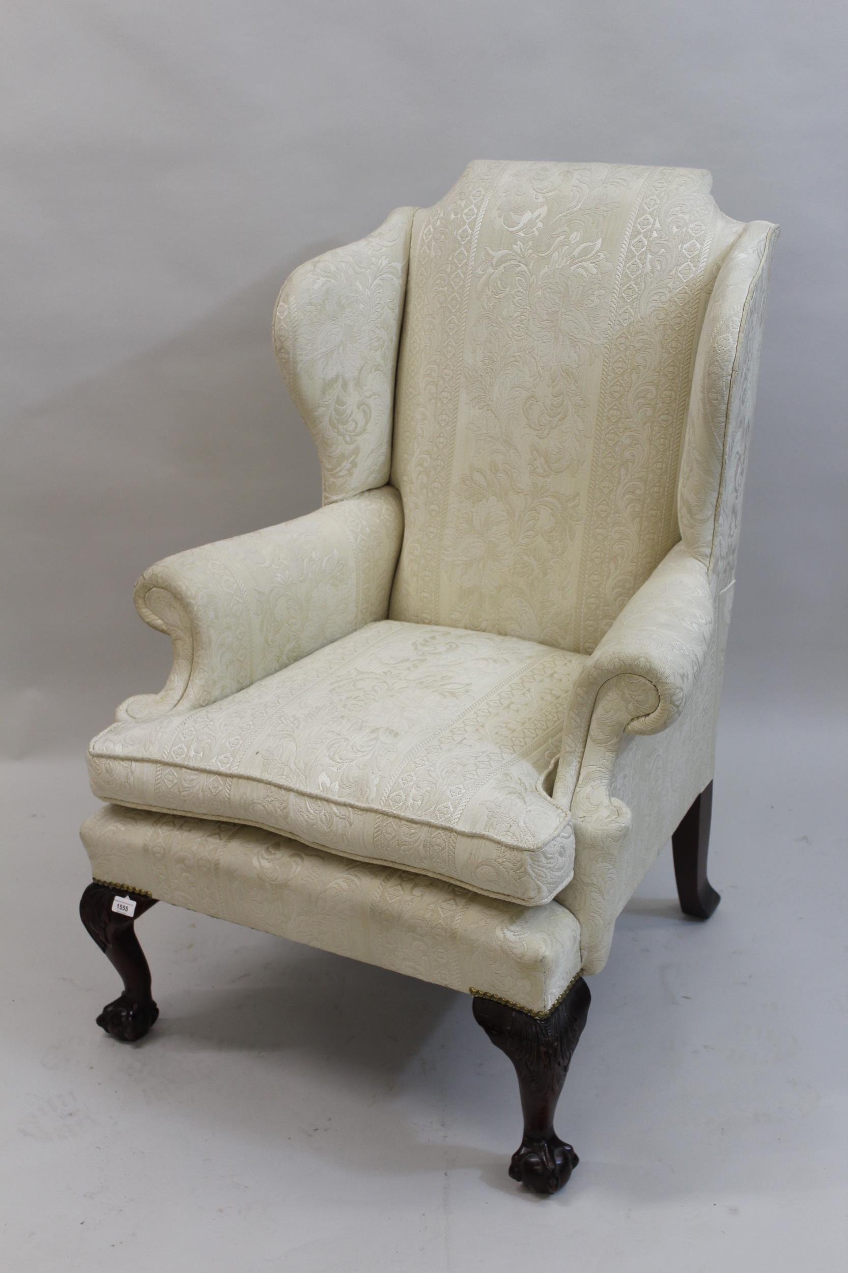 20th Century wing back armchair having cream damask upholstery with loose cushion, raised on