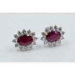 Pair of 18ct white gold oval ruby and diamond cluster ear studs