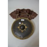 Small Indian temple gong on a carved hardwood wall bracket, with beater, the gong 10.5ins diameter