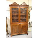 Edwardian mahogany bookcase, the carved moulded cornice above a pair of astragal glazed doors