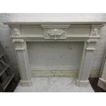 Large white marble fire surround having a moulded mantelpiece, above a central urn with bows and