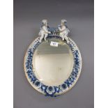Late 19th / early 20th Century Sitzendorf oval wall mirror with cherub surmount and floral encrusted