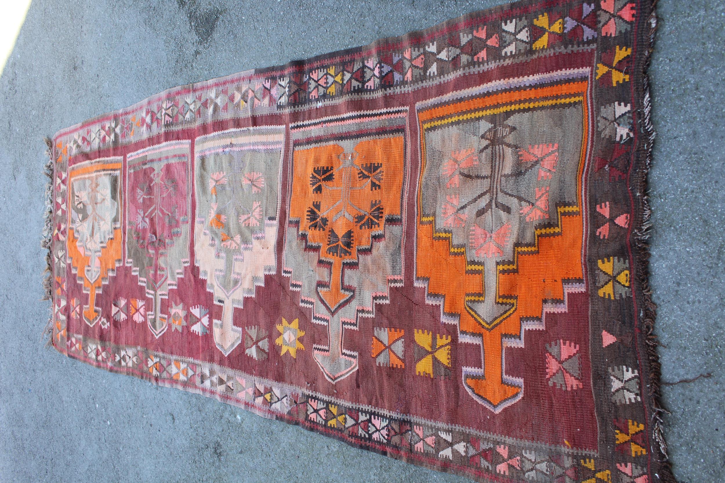 Kelim runner of all-over geometric design on a wine ground, approximately 10ft 6ins x 3ft 6ins