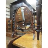 Oval mahogany swing frame toilet mirror, together with a small carved footstool on shaped supports