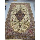 Indian carpet with a lobed medallion and all over floral design on an ivory ground with borders,