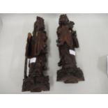 Pair of oriental carved hardwood figures of sages (at fault), 15ins high and 14.5ins high,