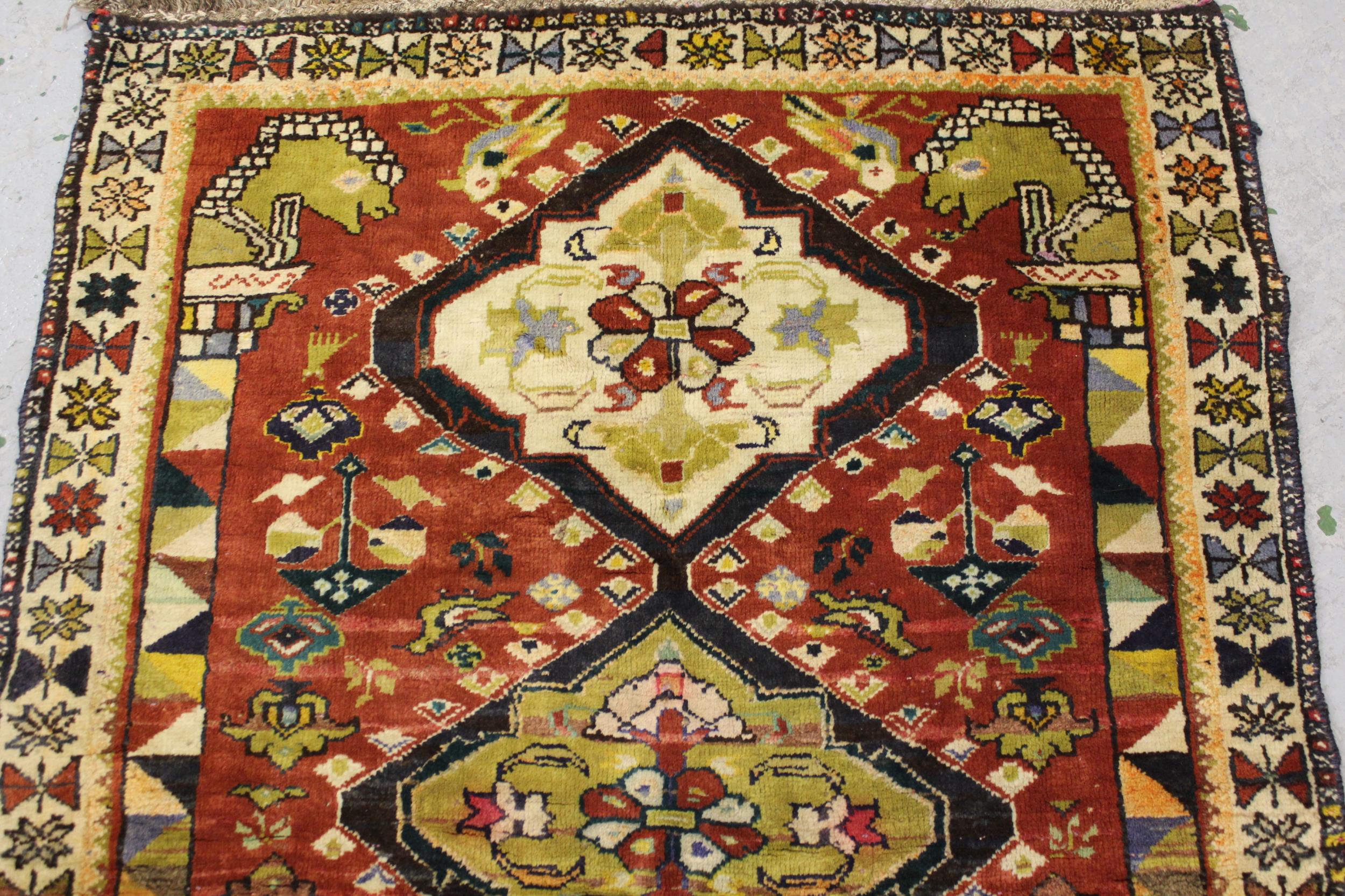 Kurdish rug with a triple pole medallion design on rose ground, with all over further stylised - Image 2 of 4
