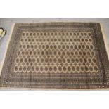 Pakistan Bokhara carpet with six rows of gols on a beige ground with borders, 10ft x 7ft 4ins