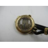 Continental Ladies circular gold wristwatch, with a diamond chip set bezel on a plated and linen