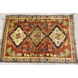 Kurdish rug with a triple pole medallion design on rose ground, with all over further stylised