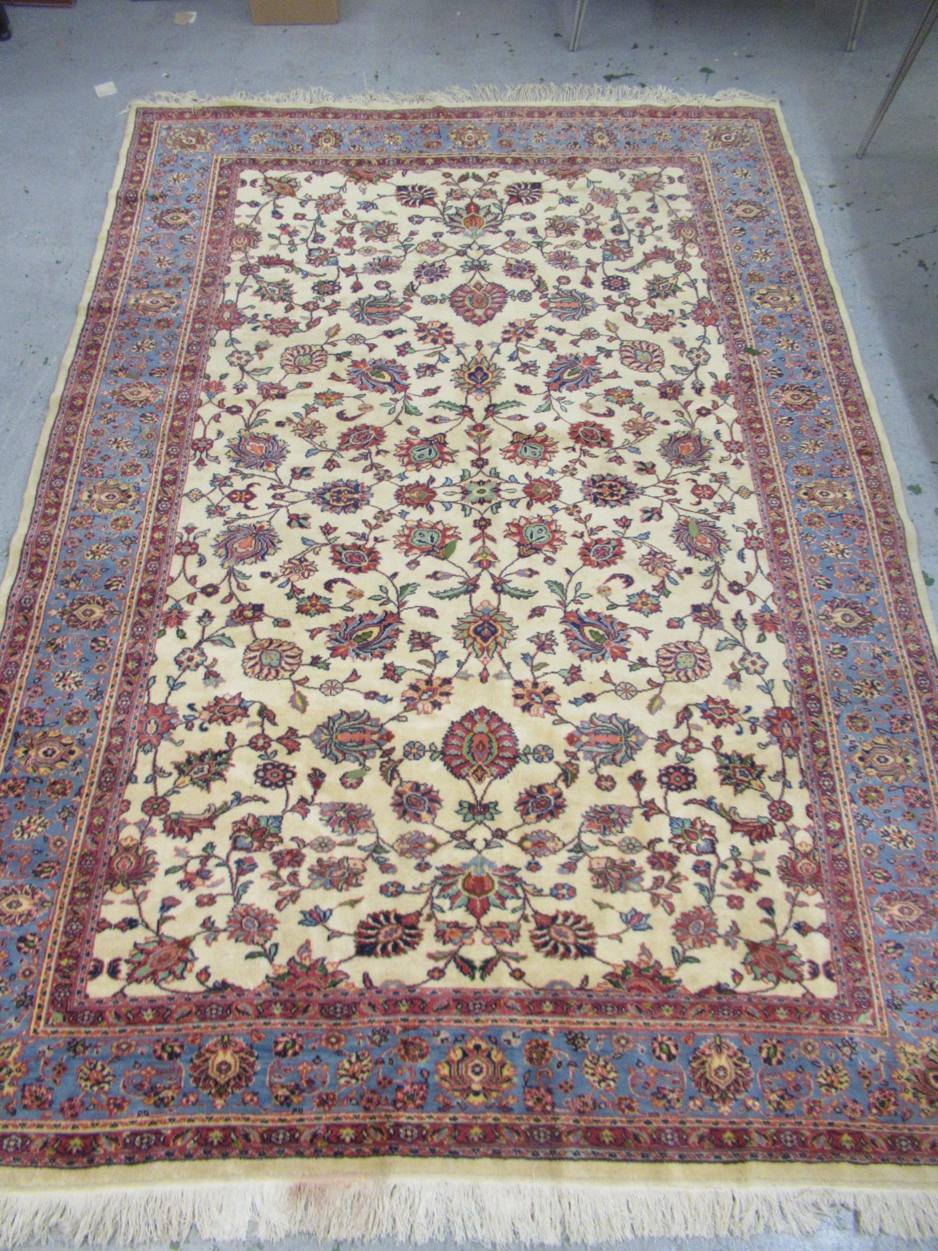 Indian carpet with an all over stylised floral design on ivory ground with pale blue borders, 140ins