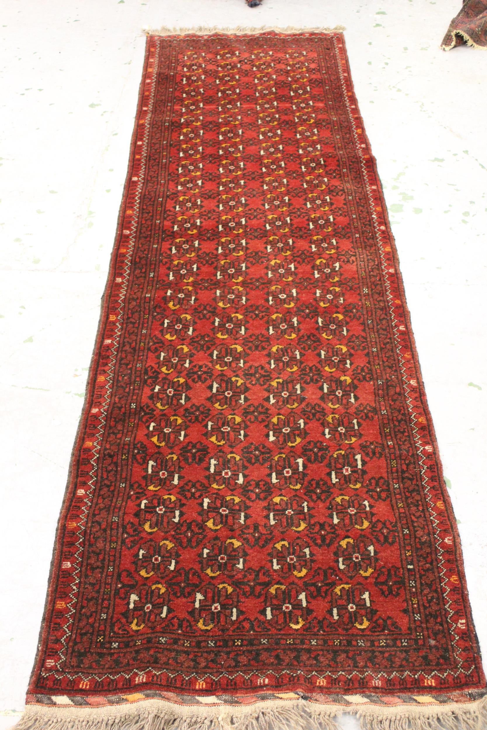Afghan runner with four rows of gols, on a deep red ground with borders, 9ft 3ins x 2ft 8ins
