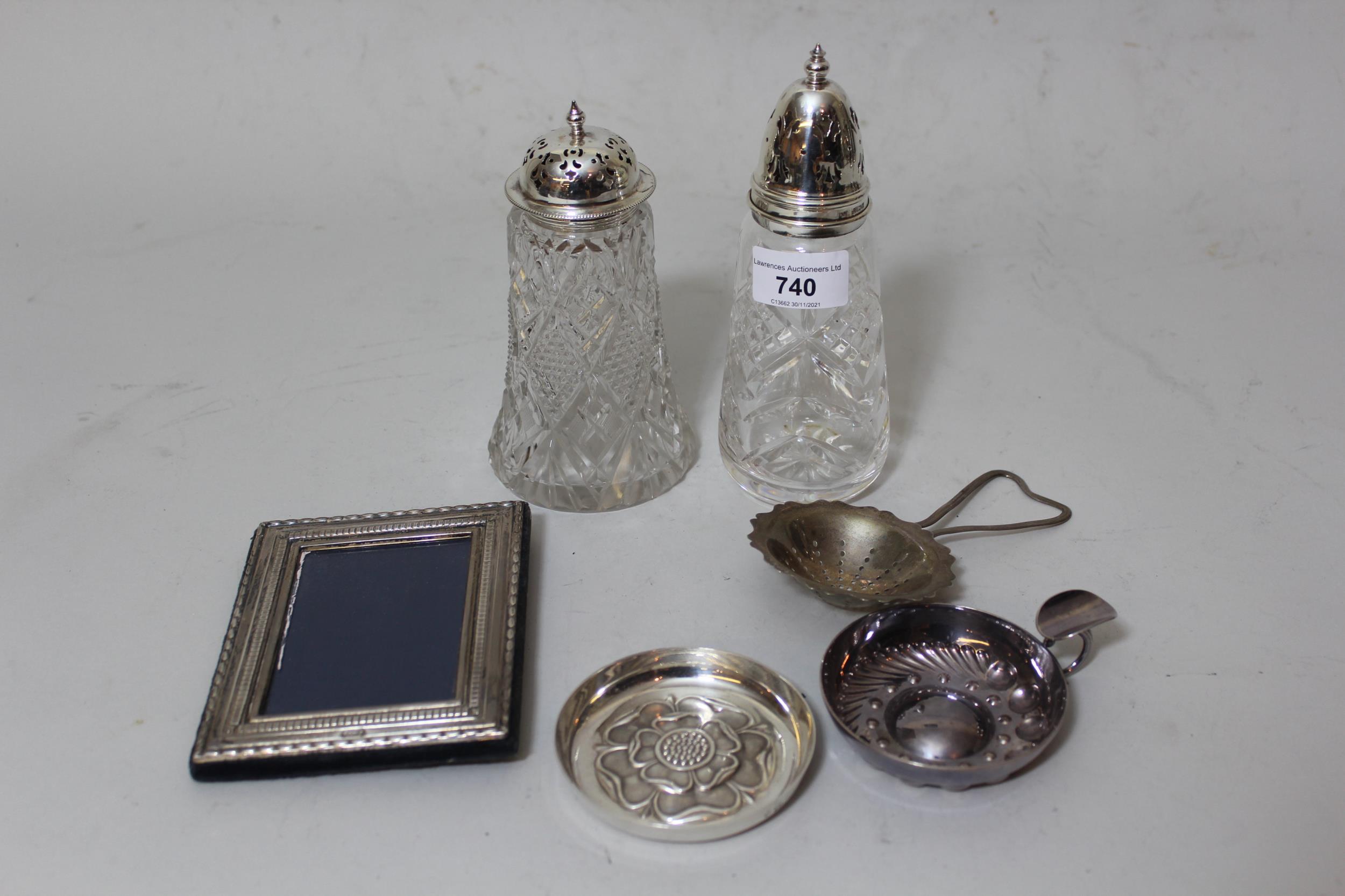 Two silver mounted cut glass sugar casters, small silver mounted photograph frame, silver tea