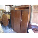 Mahogany three door wardrobe, circa 1930, the carved and moulded cornice above three panel doors