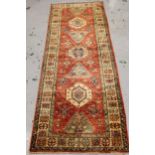 Modern Afghan Ziegler type runner with a repeating medallion and stylised floral design on a brick