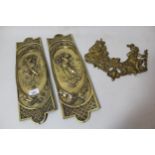 Pair of relief cast brass door plates, together with another similar, in the form of two figures