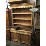 20th Century pine dresser having moulded cornice above three fixed shelves, with carved applied half