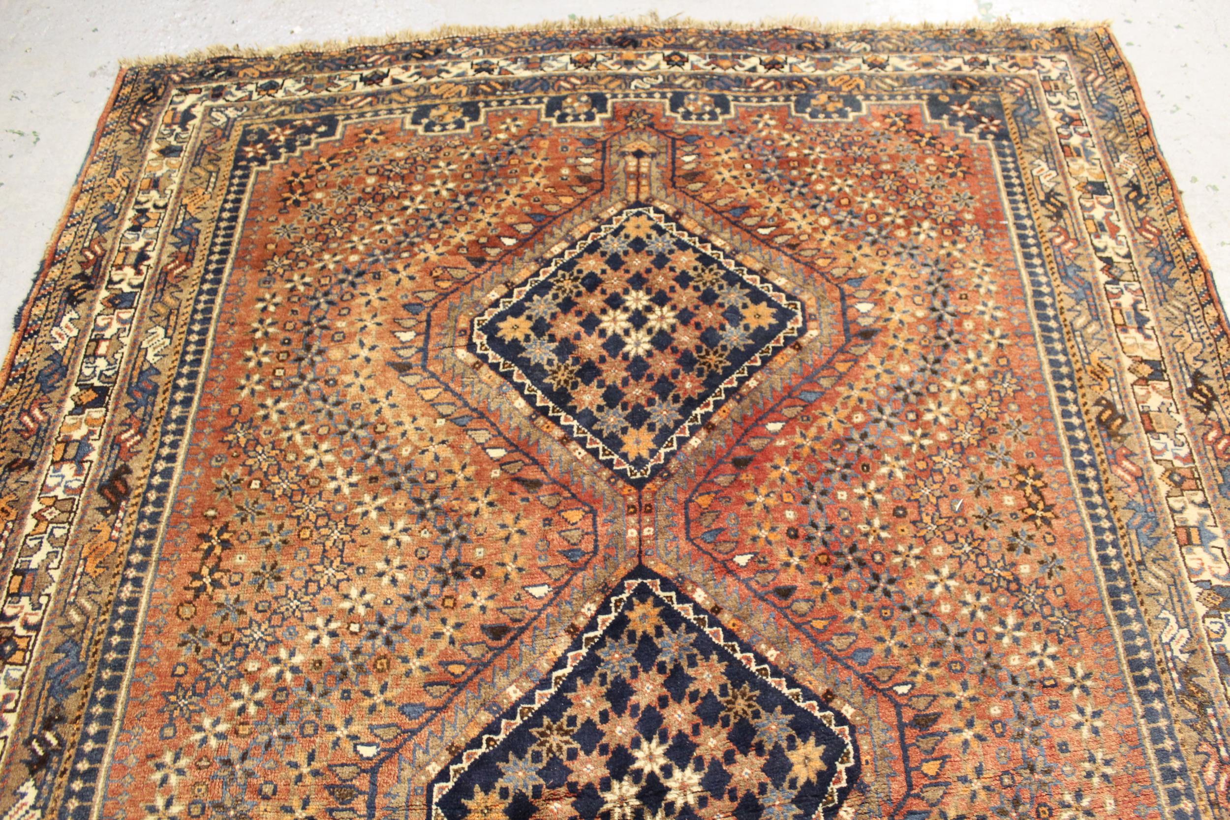 Small Shiraz carpet with a triple pole medallion design on a red ground with borders, 10ft - Image 2 of 4