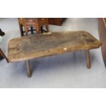 Antique oak hog bench, the thick plank top on roughly hewn splay supports, 51.5ins x 21ins