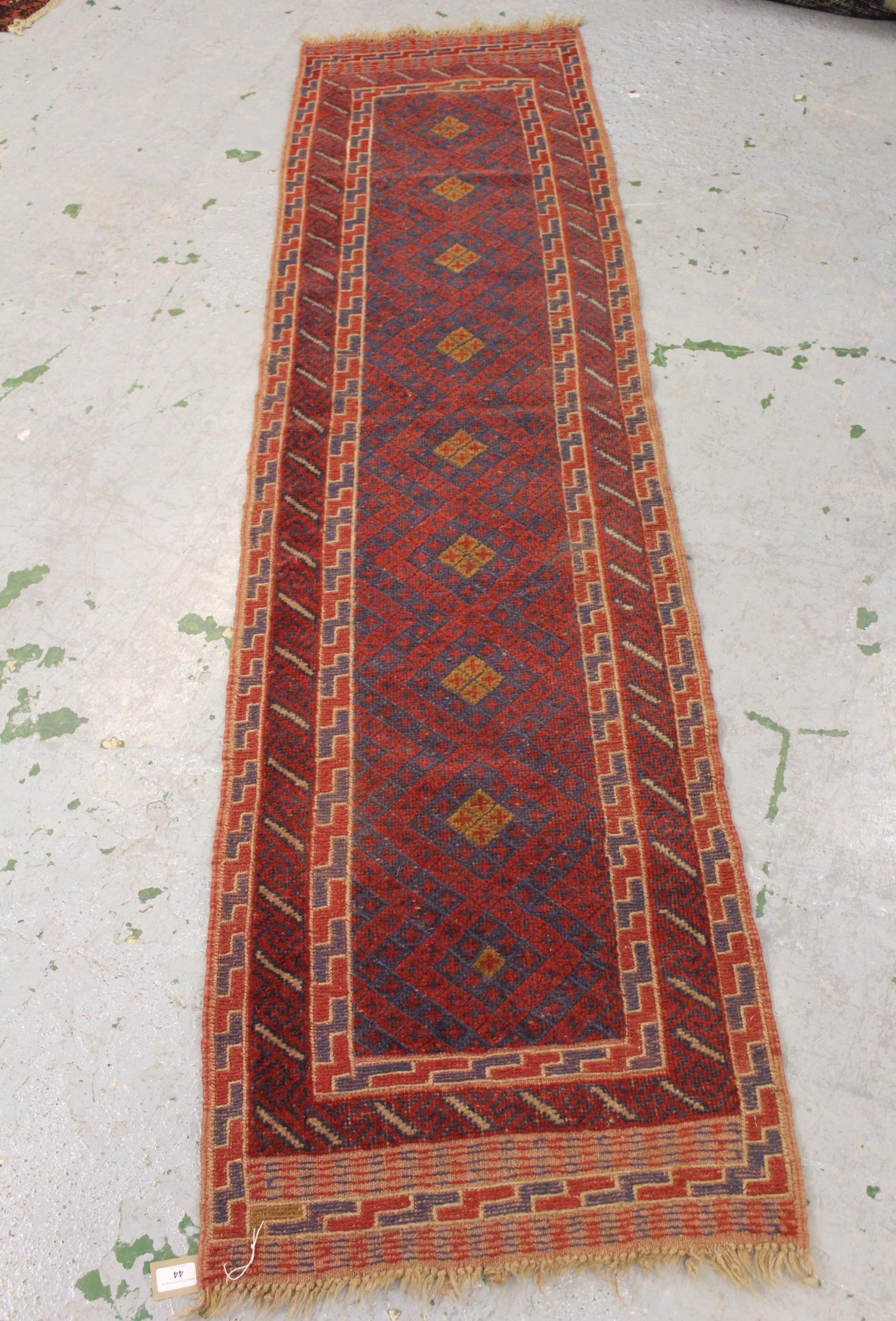 Small Belouch runner with a stylised design in shades of red, blue and beige, 7ft8ins x 2ft