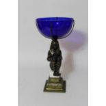 Reproduction patinated metal centrepiece in the form of a seated Egyptian figure beneath a blue