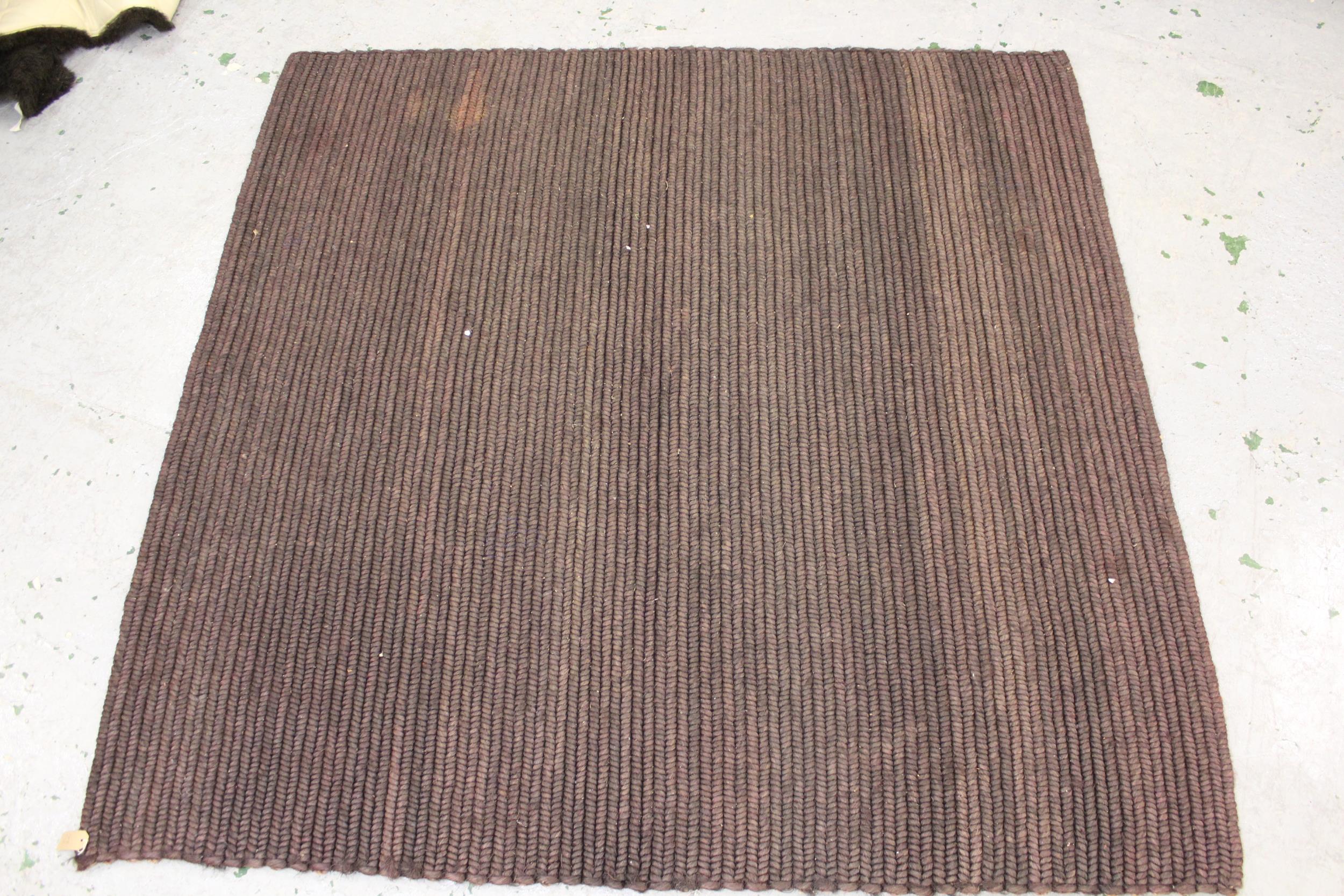 Flat woven coir rug, 7ft square approximately together with a dark brown sheepskin rug and a Chinese
