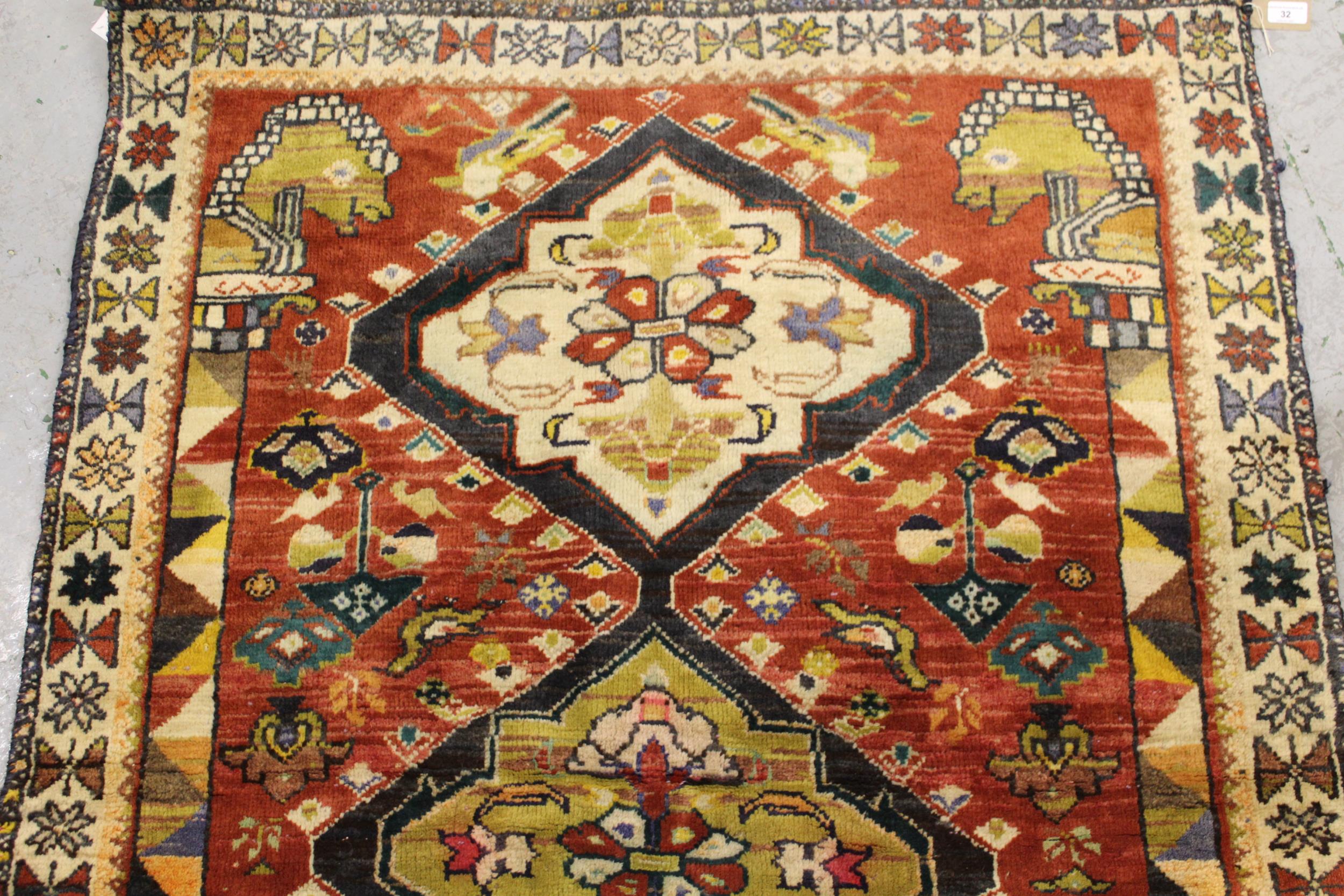 Kurdish rug with a triple pole medallion design on rose ground, with all over further stylised - Image 3 of 4