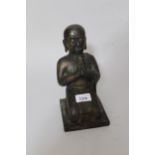 Antique patinated bronze figure of kneeling Buddha with traces of gilt and vertdegris, 9ins high