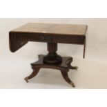 George IV mahogany drop-leaf sofa table, the figured top above a carved and moulded frieze with