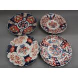 Four various 19th Century Imari chargers decorated in iron red and blue with scalloped edges, the