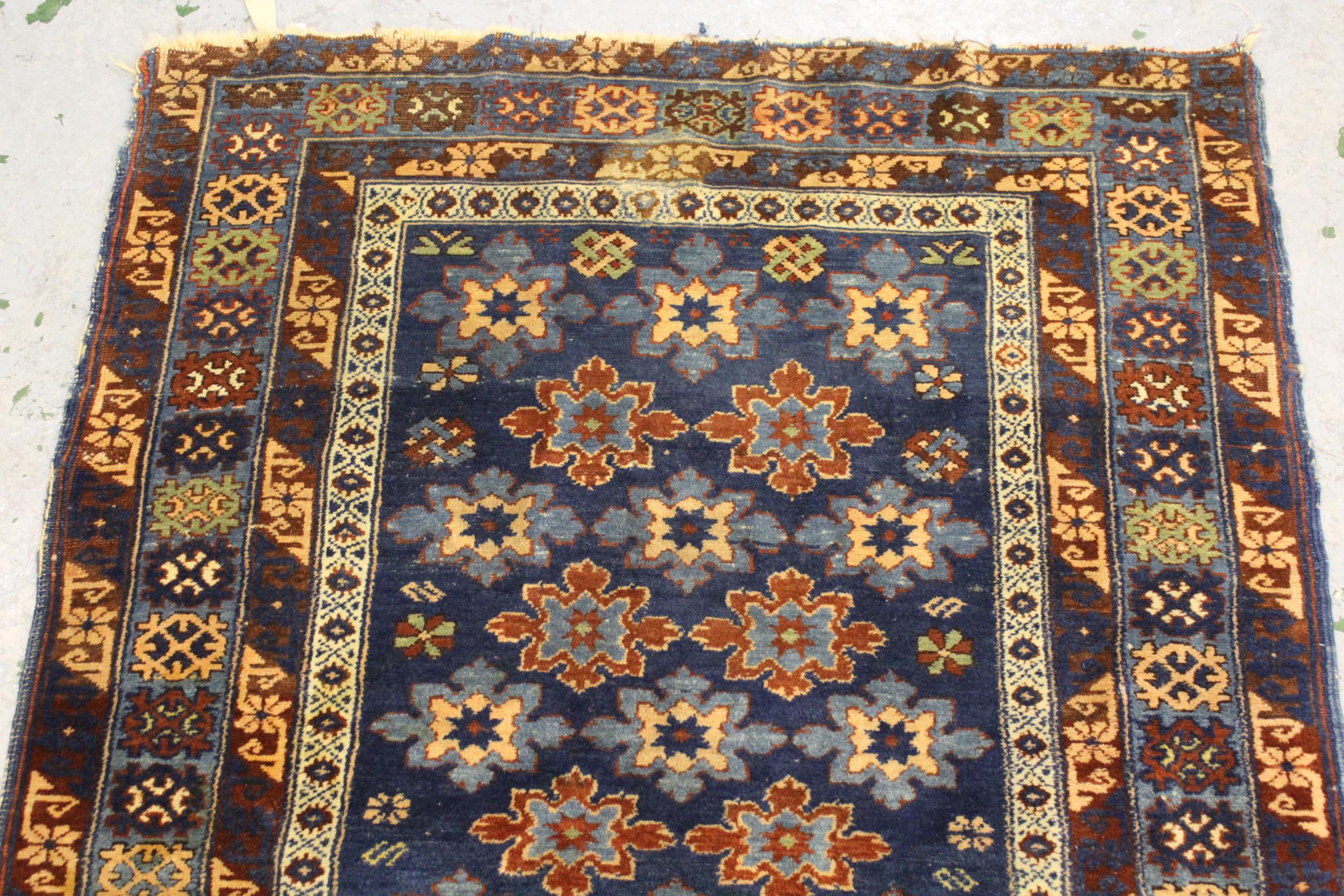 Small Belouch rug with an all over stylised flower head design on a blue ground with borders, 4ft - Image 3 of 4