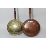 Antique copper warming pan with turned fruitwood handle, together with a similar brass warming pan