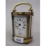 Late 19th / early 20th Century French brass carriage clock, the oval case enclosing an enamel dial