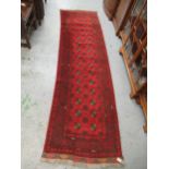 Afghan runner with two rows of gols on a red ground with borders, 9ft 6ins x 2ft 10ins approximately